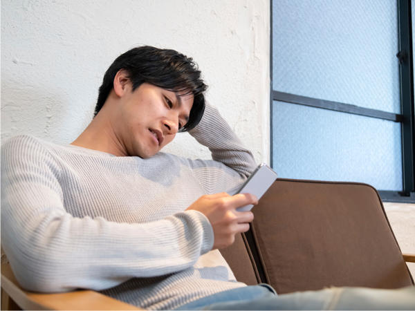 スマホを見る男性の写真
